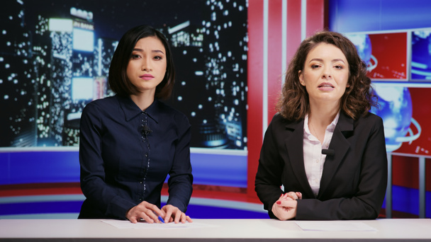 Diverse journalists host night show live on tv network, presenting breaking news segment in newsroom. Media presenters team addressing daily international events with television reportage. - Photo, Image