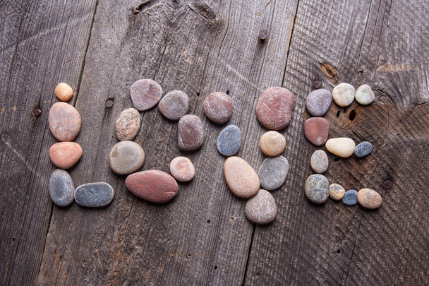 Liebeserklärung aus kleinen Steinen auf Holztisch - Foto, Bild