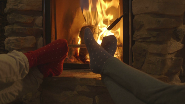 Women relaxing beside fireplace - Footage, Video