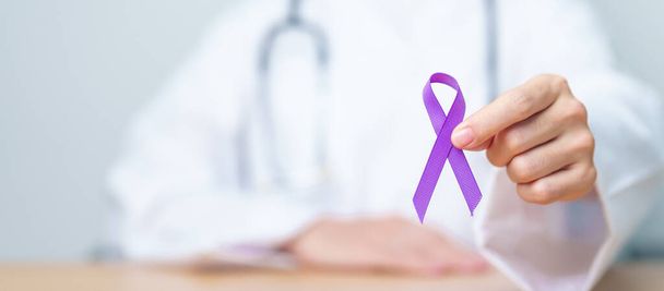 Médecin tenant un ruban violet pour la violence, le pancréas, l'œsophage, le cancer du testicule, la maladie d'Alzheimer, l'épilepsie, le lupus, la sarcoïdose et la fibromyalgie. Mois de sensibilisation et concept de Journée mondiale du cancer - Photo, image