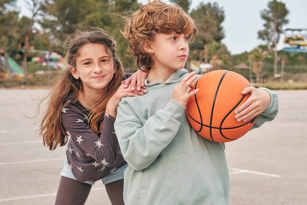 楽しいですフレンドリーな十代の男の子と女の子とともにバスケットボールは夏の週末に街の通りに立って - 写真・画像