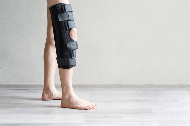 膝のブレースのクローズアップを着用している男性. 骨,筋肉,靭帯の回復を促進するのに役立ちます - 写真・画像