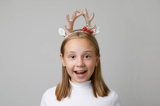 Kerstmis verrast kind meisje in Kerstmis haar deco op witte achtergrond - Foto, afbeelding