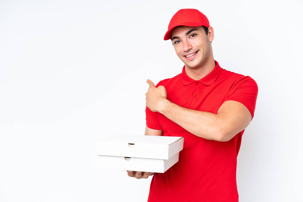 Доставка піци кавказький чоловік з робочою формою збирання піцерії коробки ізольовані на білому тлі, вказуючи назад
 - Фото, зображення