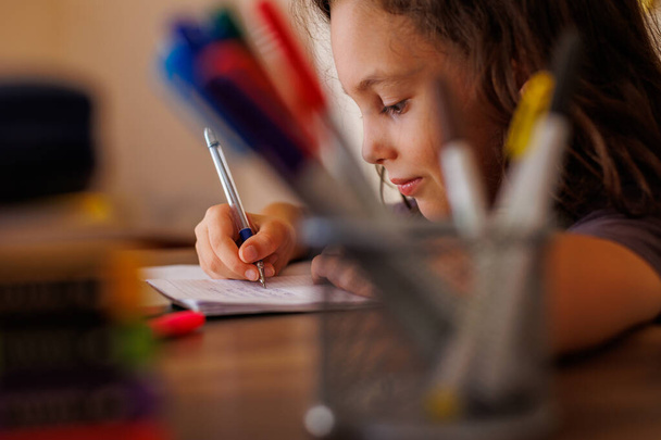Primer plano de la mano de los niños. el niño usa un lápiz para practicar la escritura de cartas. El niño aprende a escribir en un cuaderno. concepto de educación preescolar. - Foto, imagen