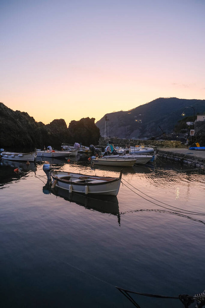barcos en el puerto de Framura, Liguria, Italia durante la puesta del sol cielo a través de acantilados - Foto, imagen
