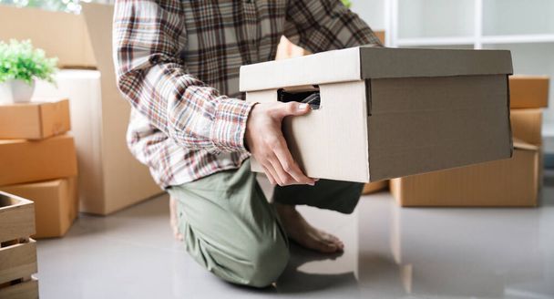 День переезда. закрыть мужской азиатской руки с коробкой для перемещения из старого в новый дом или место жительства. - Фото, изображение