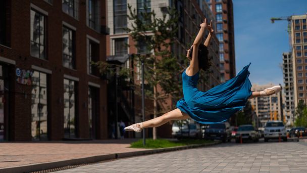 Beautiful Asian ballerina dancing outdoors. Urban landscape. Grand jete - 写真・画像