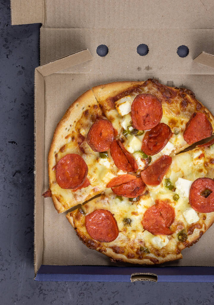 Pizza z fetą, chili, serem i peperoni - w opakowaniach kartonowych z pizzą - Zdjęcie, obraz