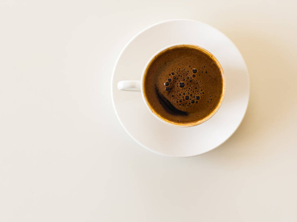 Küçük beyaz porselen bardak ve çay tabağı sıcak siyah Türk kahvesi, kahve kültürü konsepti. Beyazda izole edilmiş. Üst Manzara. Yüksek kalite fotoğraf - Fotoğraf, Görsel
