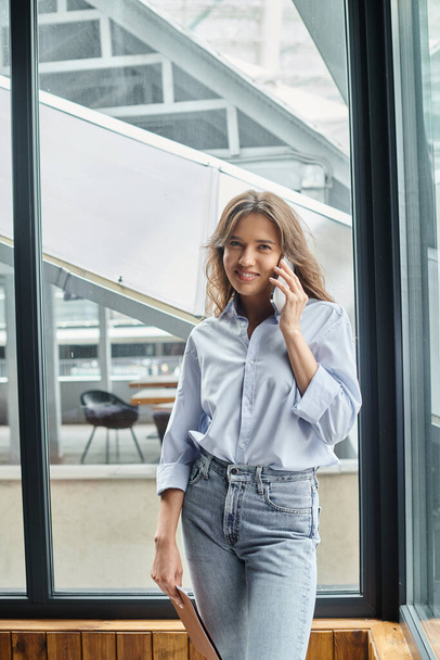 young attractive woman in business casual attire smiling and talking on phone, coworking concept - Foto, Imagem