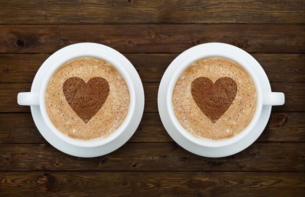 zwei Tassen Kaffee mit Herzen auf dem Holz - Foto, Bild