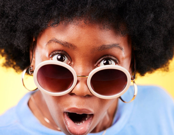 Surprise, femme noire et choc sur le visage avec des lunettes de soleil, mode et vente folle, affaire ou offre en arrière-plan studio. Confus, portrait et personne africaine avec choqué, wow ou emoji pour la promotion. - Photo, image