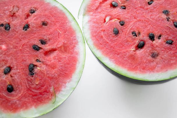 Dvě poloviny melounu na bílém pozadí. Letní bobule - červený meloun. Zralá voda se semeny. - Fotografie, Obrázek