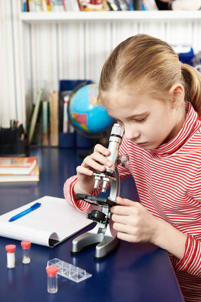 Girl looking through a microscope - Фото, изображение