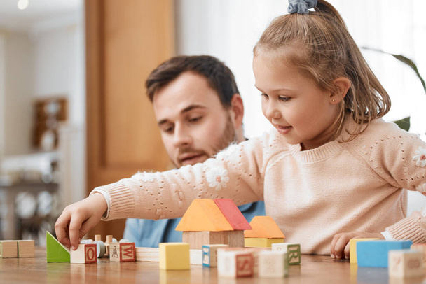 Building blocks, toys and girl playing with dad in living room for education, development and learning through creative games. Montessori, child and father bonding with kid in family home lounge. - Photo, Image