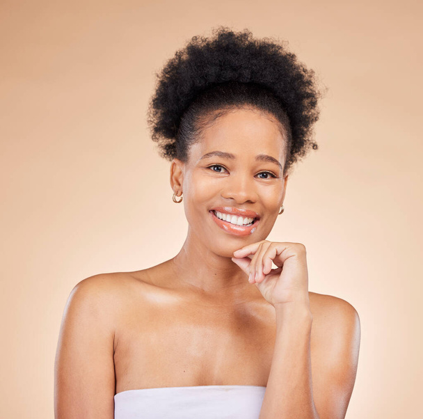 Gezicht, huidverzorging en schoonheid van de zwarte vrouw, gelukkig en geïsoleerd op een bruine achtergrond in de studio. Portret glimlach, natuurlijke cosmetica en Afrikaans model in gezichtsbehandeling voor esthetiek, welzijn of gezondheid. - Foto, afbeelding
