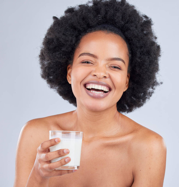 Mujer feliz, retrato y bebida de leche en estudio para una piel sana, dieta y calcio sobre fondo blanco. Modelo africano, batido lácteo y vaso de batido de vainilla para nutrición, proteínas y belleza. - Foto, Imagen