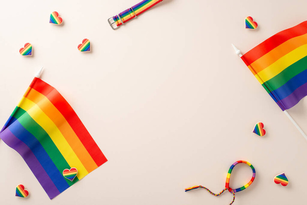 ЛГБТ-месяц с плоской укладкой различных аксессуаров, таких как радужные флаги, декоративные браслеты в форме сердца и пояс на бежевом фоне для текста - Фото, изображение