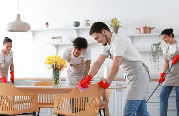 Young janitors cleaning in kitchen - Foto, imagen