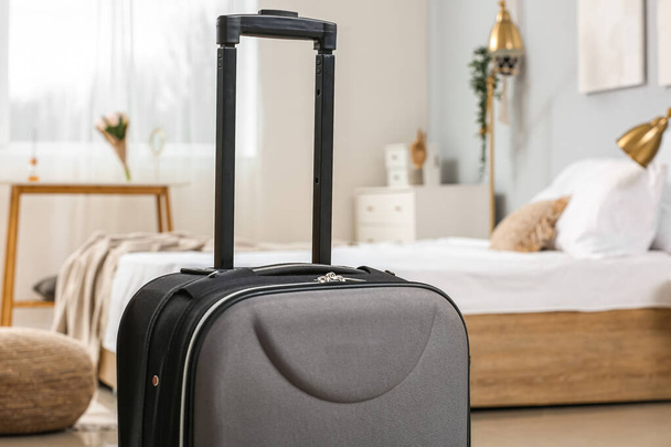 Black suitcase in light bedroom, closeup - Photo, Image