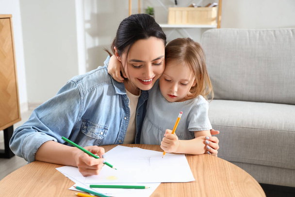 jonge vrouw met haar kleine dochter tekening thuis - Foto, afbeelding