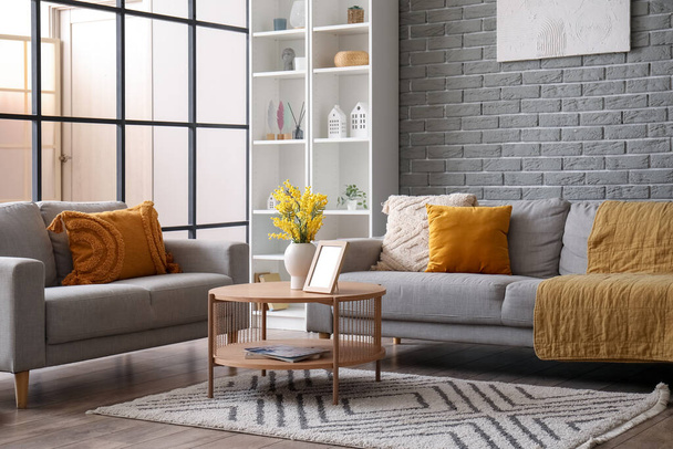 Интерьер современной гостиной с диванами, журнальным столиком и полками - Фото, изображение