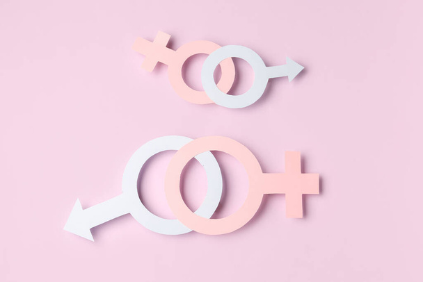 Паперові символи чоловічої та жіночої статі на бузковому тлі - Фото, зображення