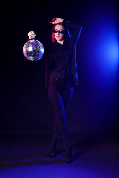 νεαρή γυναίκα με ντίσκο μπάλα σε μαύρο φόντο - Φωτογραφία, εικόνα