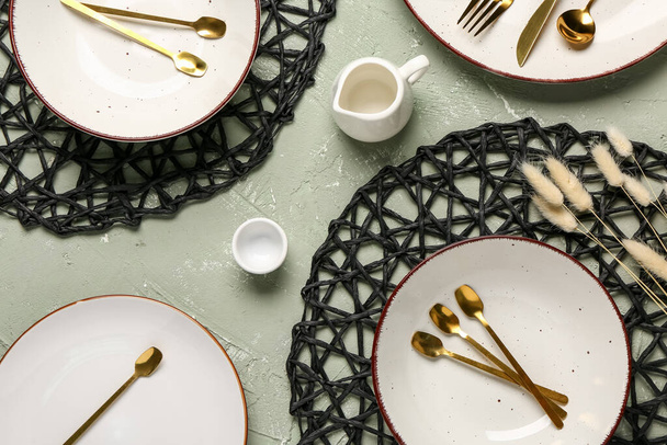 Asztalbeállítás tiszta tányérokkal, evőeszközökkel és szárított lagurusszal grunge alapon - Fotó, kép