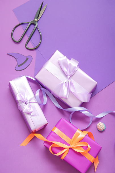 Украшения на Хэллоуин с подарочными коробками и оберточной бумагой на фиолетовом фоне - Фото, изображение