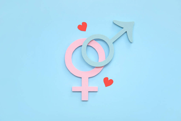Weibliche und männliche Geschlechtssymbole und Herzen auf blauem Hintergrund - Foto, Bild