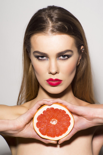 Glamour girl holding grapefruit - Foto, afbeelding