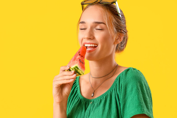 Giovane donna mangiare anguria fresca su sfondo giallo, primo piano - Foto, immagini
