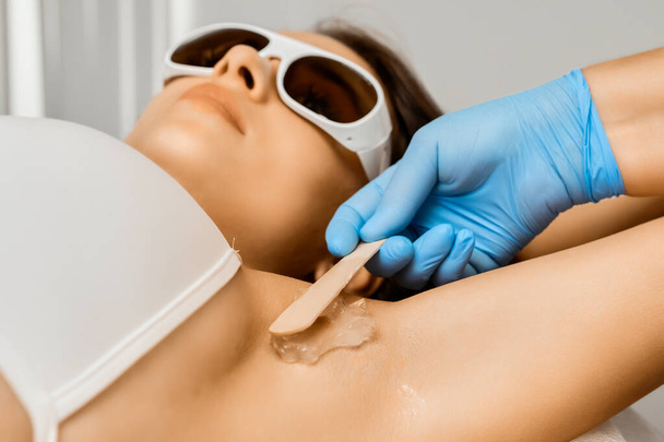 Lähikuva kosmetologi soveltaa geeliä kainalossa laser epilaatio. - Valokuva, kuva