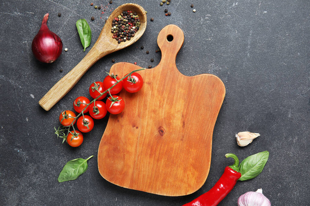 Wooden board with fresh vegetables on grunge black kitchen table - Photo, Image
