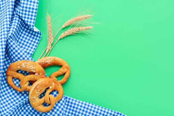 Pretzels suaves y espiguillas de trigo sobre fondo verde - Foto, Imagen
