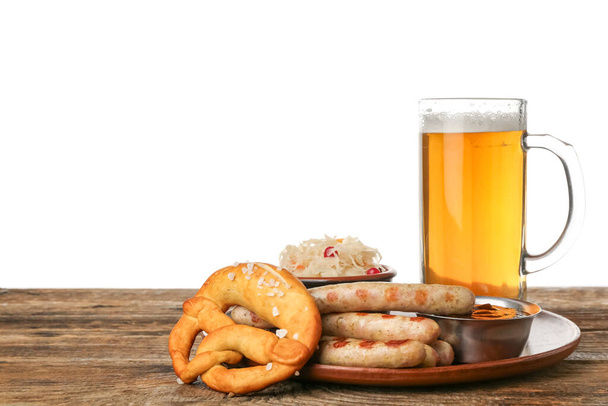 Prato com caneca de cerveja gelada, salsichas, molho, chucrute e pretzel na mesa contra fundo branco. Celebração Oktoberfest - Foto, Imagem