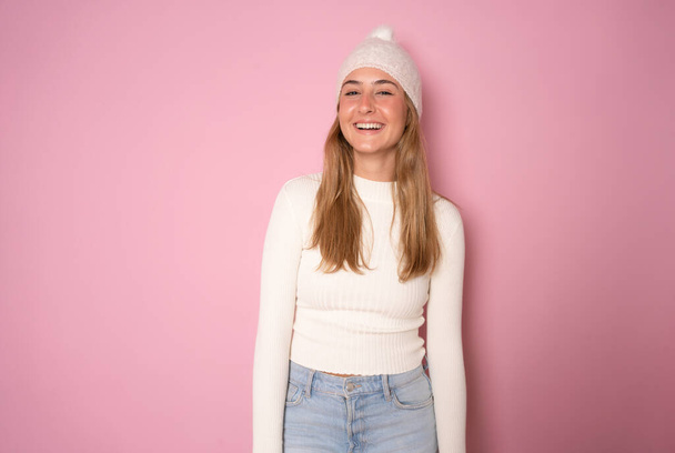Jeune femme heureuse portant des vêtements d'hiver isolés sur fond rose. - Photo, image