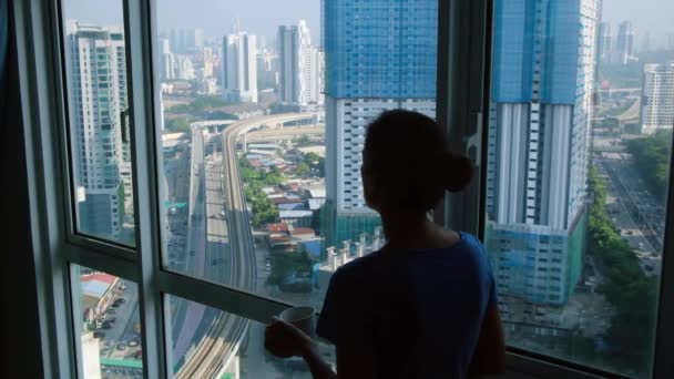 Silhouette einer Frau mit einer Tasse Tee am Fenster - Filmmaterial, Video