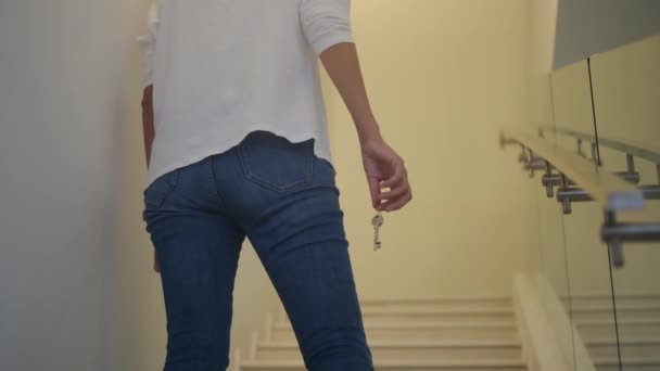 Großaufnahme weibliche Hand hält Schlüssel für neues Zuhause im Treppenhaus - Filmmaterial, Video