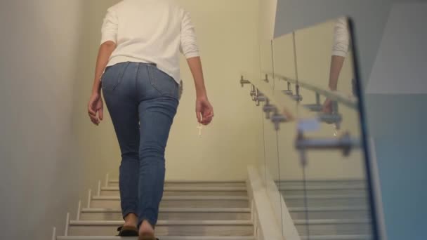 Közelkép fókusz női kéz gazdaság kulcs új otthon a lépcsőn - Felvétel, videó