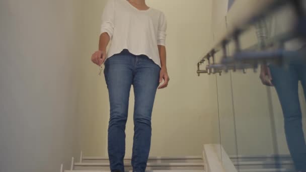 Κοντινό πλάνο εστίαση θηλυκό χέρι κρατώντας το κλειδί του νέου σπιτιού στις σκάλες - Πλάνα, βίντεο