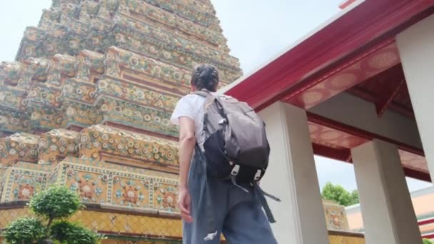 Za cestovatelkou s batohem cestování v atraktivní architektuře pagoda buddhistické kultury v jihovýchodní Asii - Záběry, video