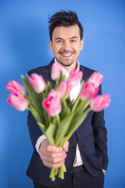 Man with flowers - Фото, зображення