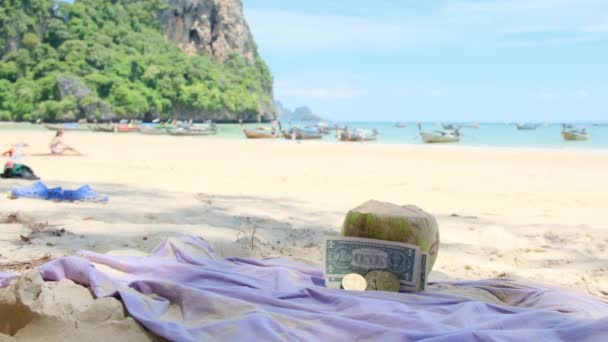 Зеленый кокос с деньгами на белом песке бирюзового морского пляжа - Кадры, видео