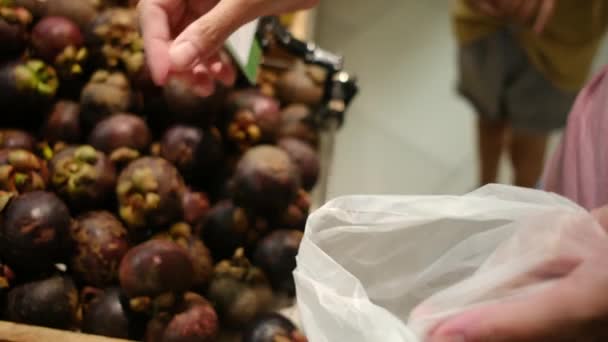 Žena brát exotické ovoce na trhu - Záběry, video