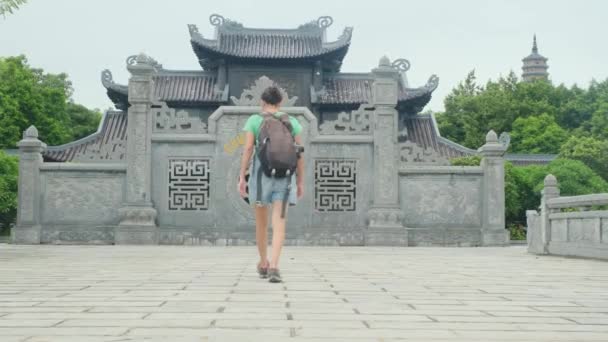 Femme de 40 ans avec sac à dos marchant à travers le temple de l'Asie du Sud-Est, capturant la culture et l'autonomisation  - Séquence, vidéo