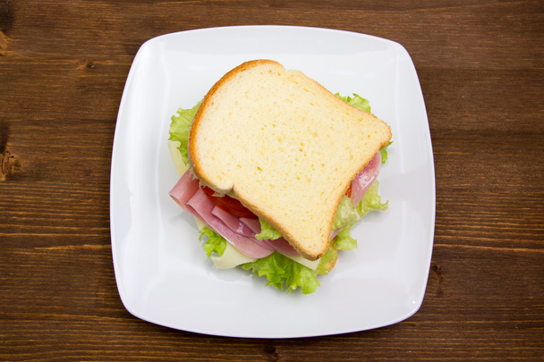 Sneetjes brood met ham en salade op hout van bovenaf - Foto, afbeelding