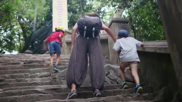 Äiti poikineen kävelee Kaakkois-Aasian temppelin läpi - Materiaali, video